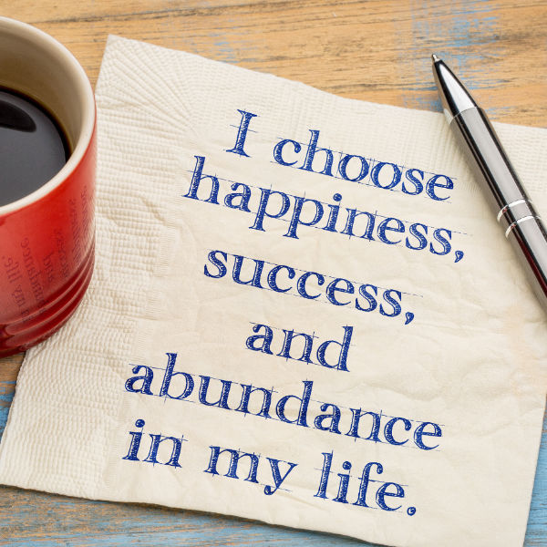 The words "I choose happiness, success, and abundance in my life" written on a paper napkin.
