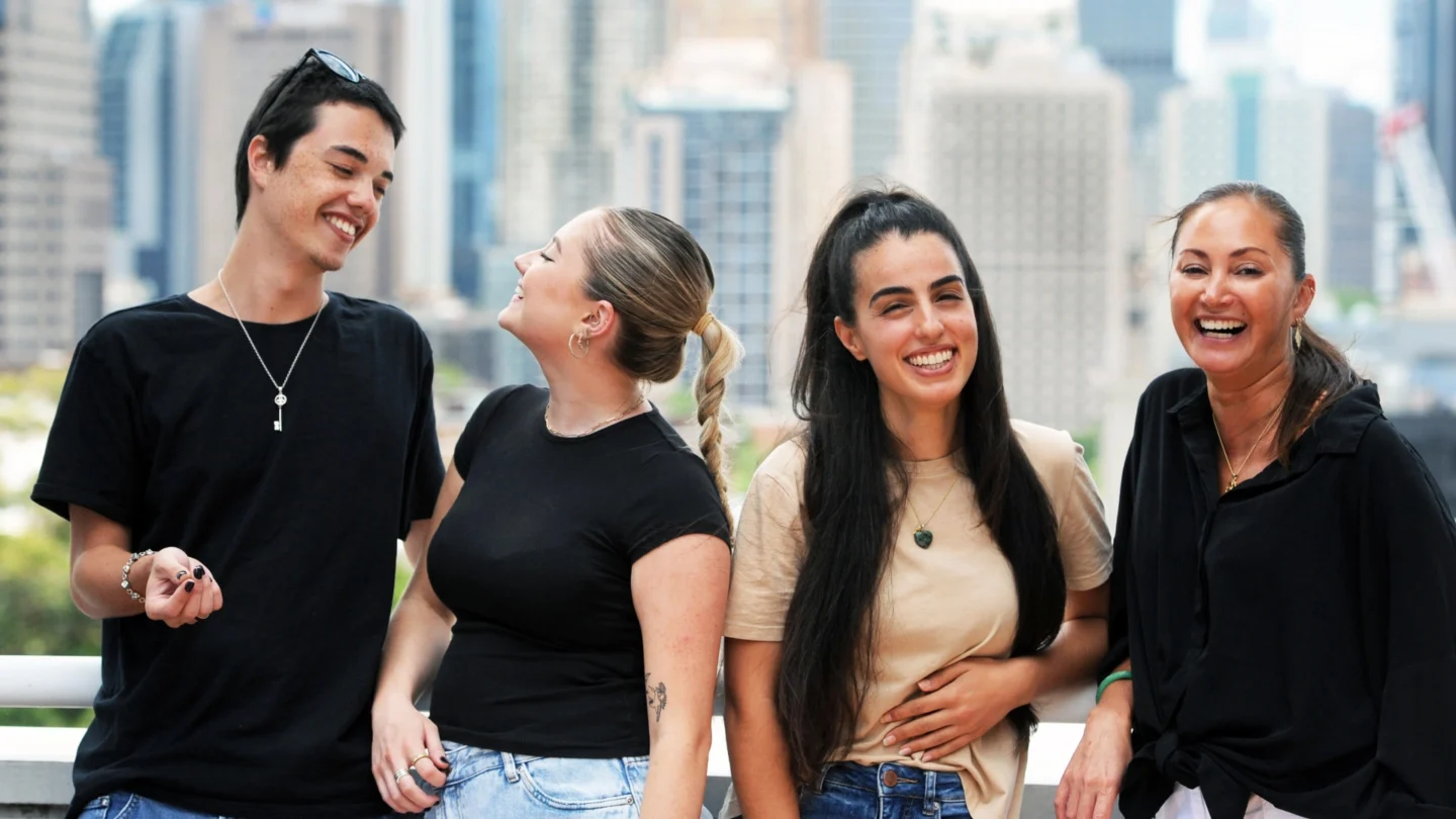 A group of CCM students smiling and happy with CBD buildings as a backdrop.